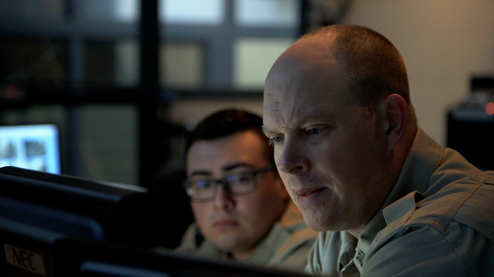 two corrections officers looking at computer