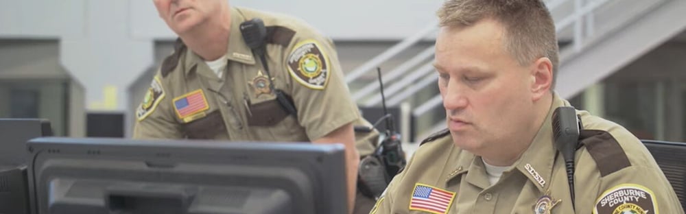 correctional officers working on computers