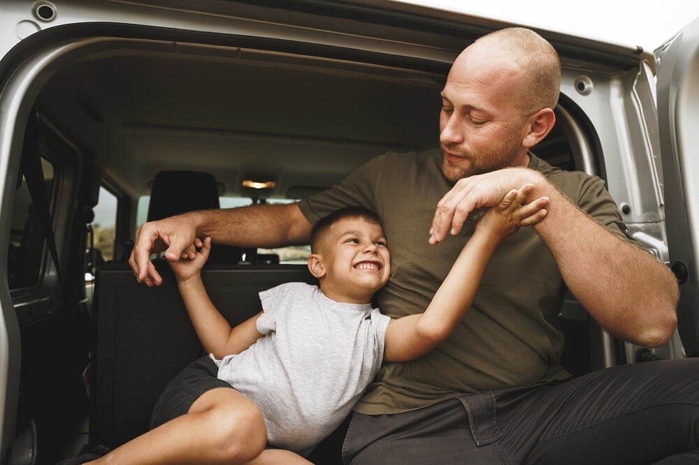happy-father-and-son-sitting-in-car-trunk-2022-01-18-23-38-21-utc
