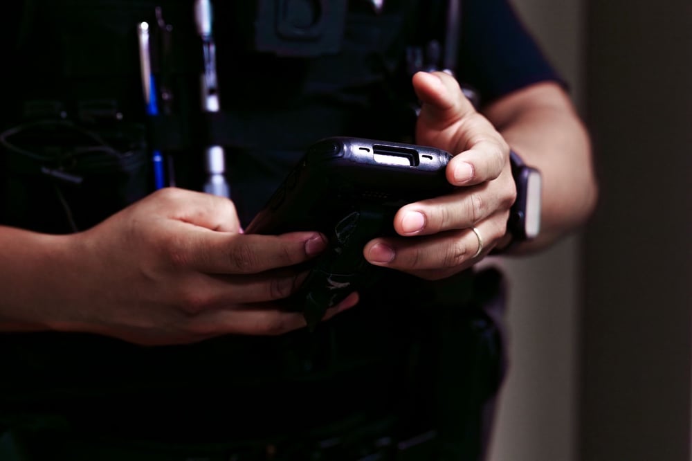 corrections officer holding SPARTAN inmate tracking device 