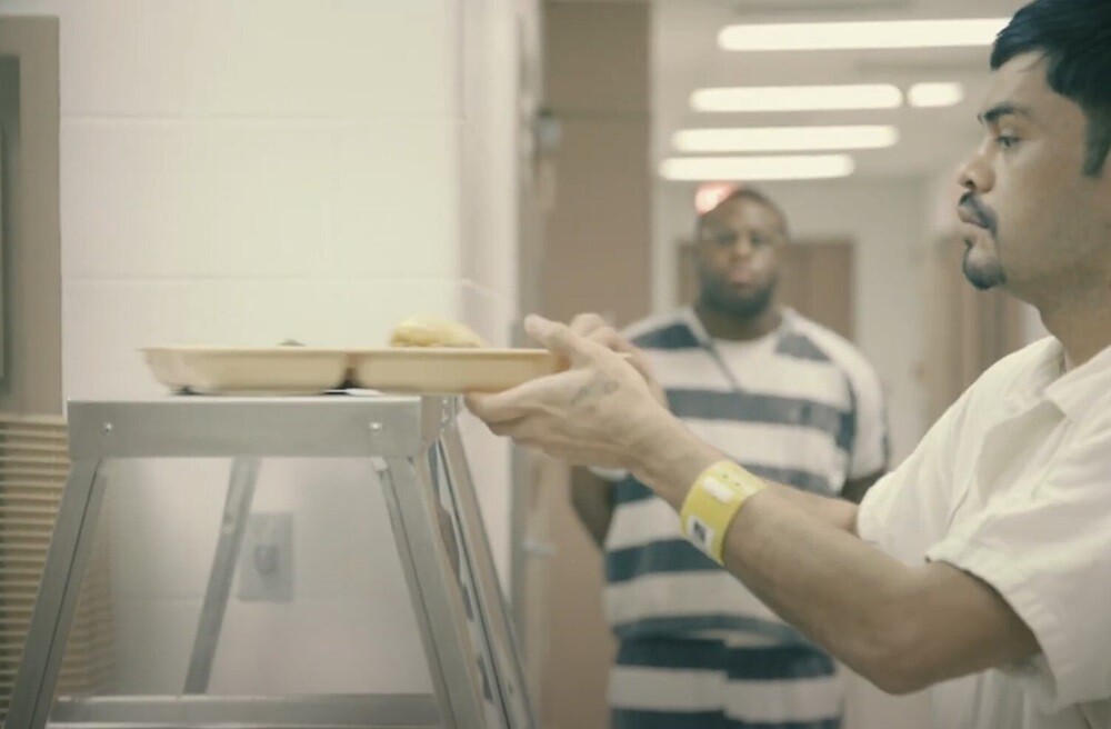 Inmate receiving meal tray